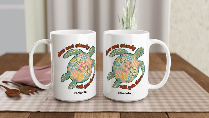 Two Slow and Steady Turtle 15oz mugs on a table, showing both sides of the design, Zen Koala Australia