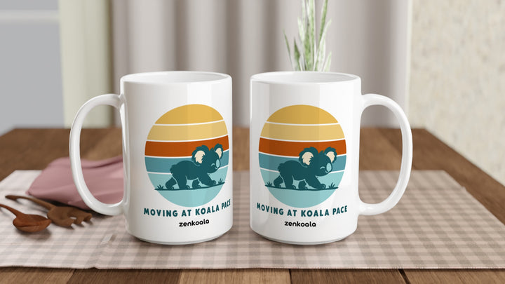 Two Moving at Koala Pace 15oz mugs on a table, showing both sides of the design, Zen Koala Australia