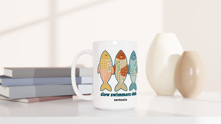 Slow Swimmers Club 15oz mug beside books and vases, Zen Koala Australia