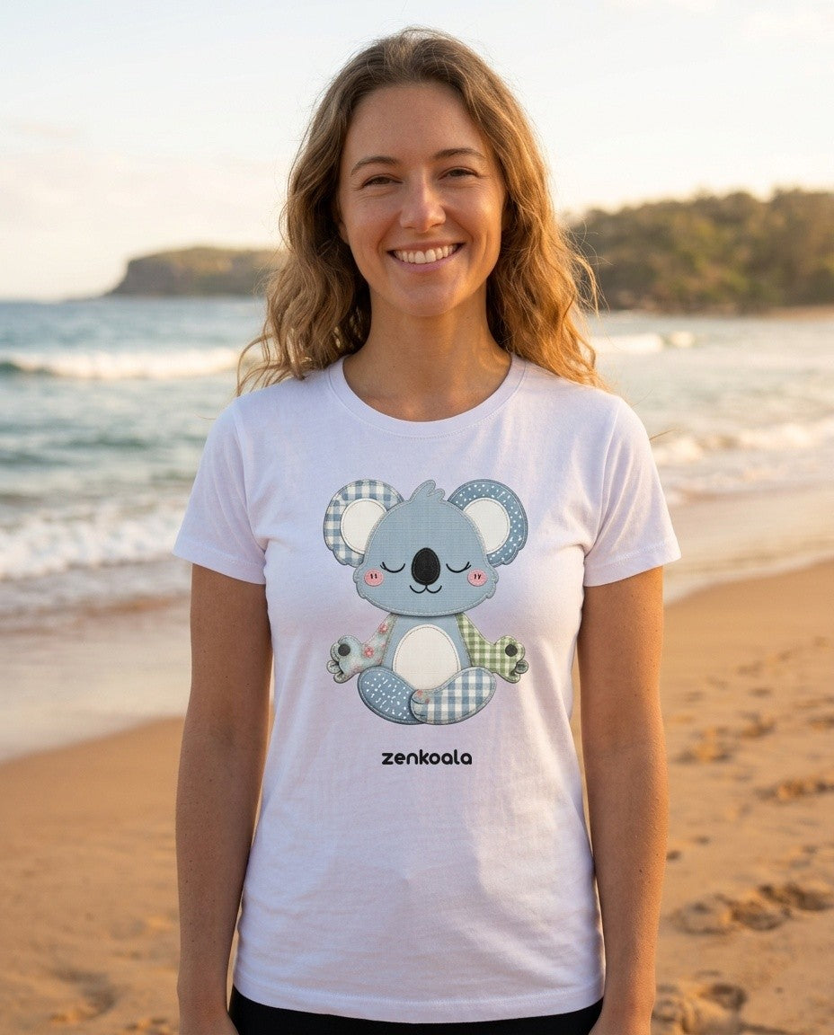 Woman on the beach wearing the ZenKoala patchwork meditating koala tee in white