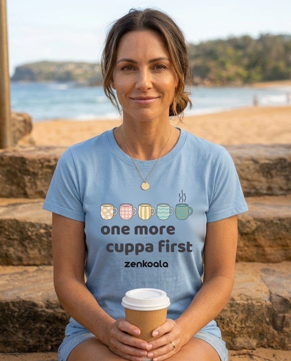 Woman on the beach in a light blue ZenKoala One more cuppa first tee