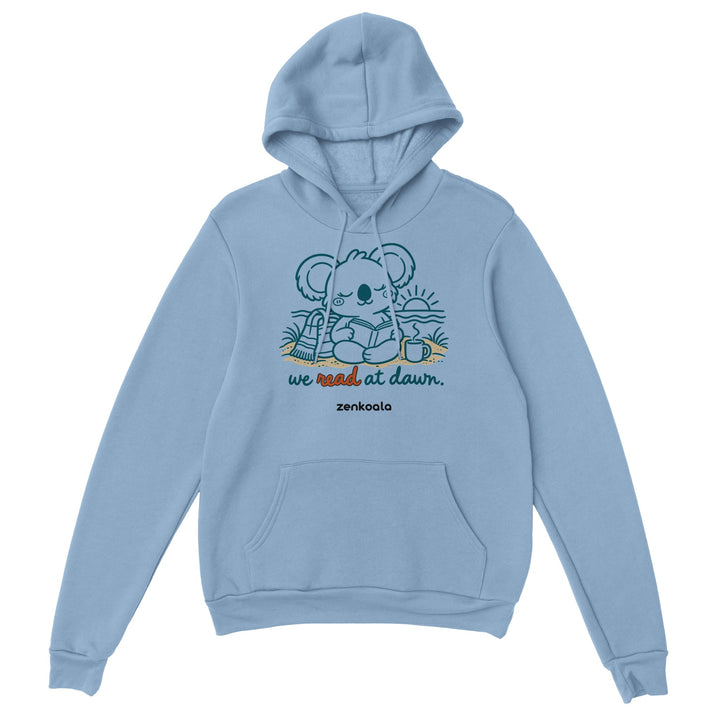 We Read at Dawn feel-good hoodie in light blue: a koala reading on the beach, Zen Koala Australia