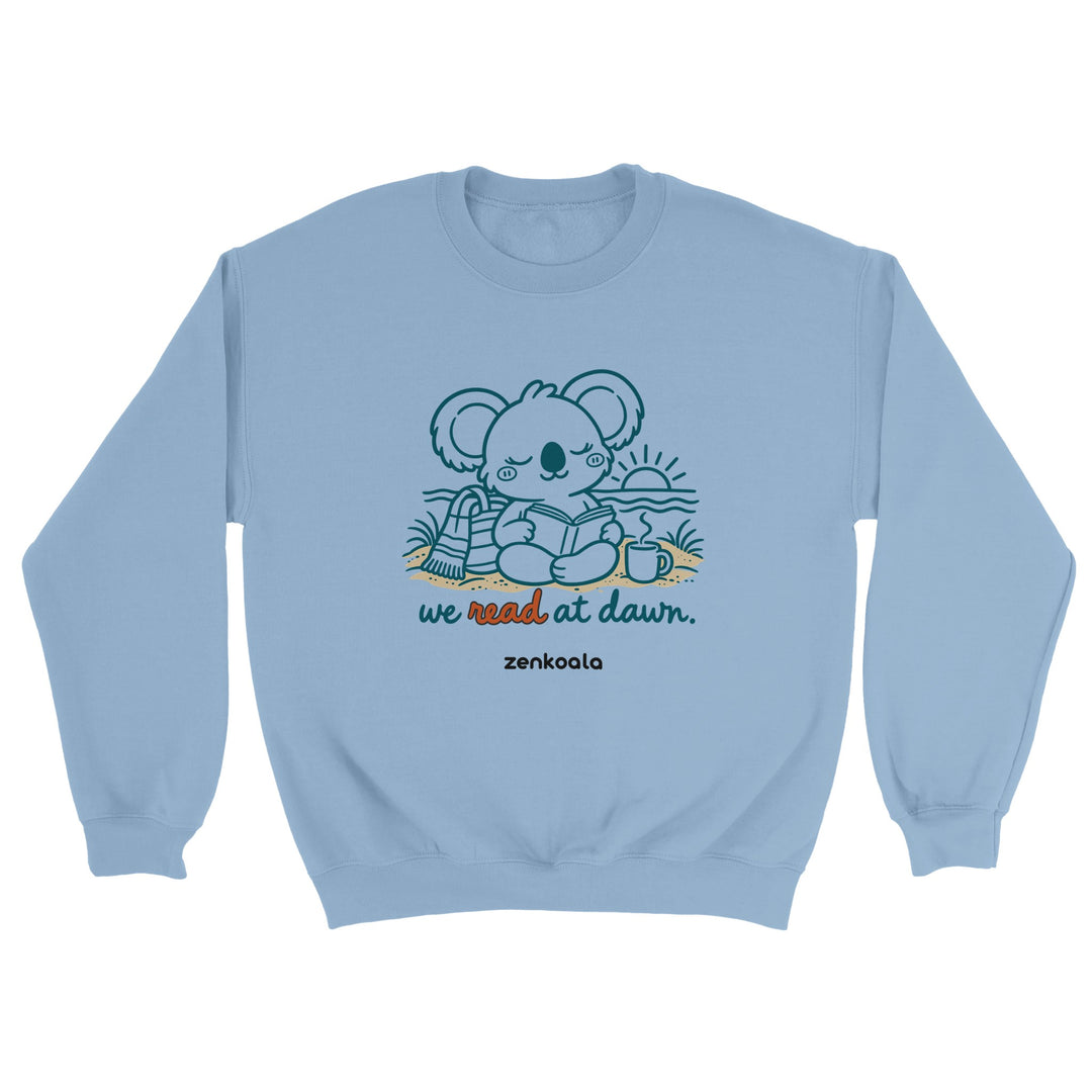 We Read at Dawn feel-good sweatshirt in light blue: a koala reading on the beach, Zen Koala Australia