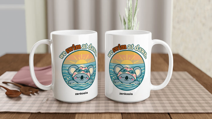 Two We Swim at Dawn 15oz mugs on a table, showing both sides of the design, Zen Koala Australia