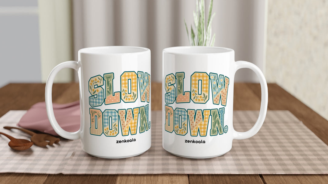 Two Slow Down Faux Patchwork 15oz mugs on a table, showing both sides of the design, Zen Koala Australia